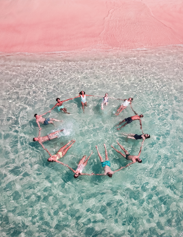 海に浮かびながら大きな輪を作る6組のカップル