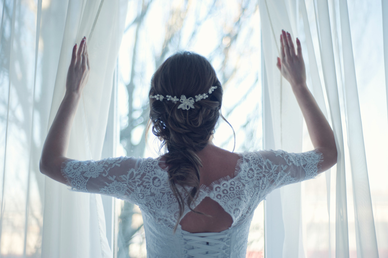 結婚式の朝カーテンを開けて窓の外を見る新婦