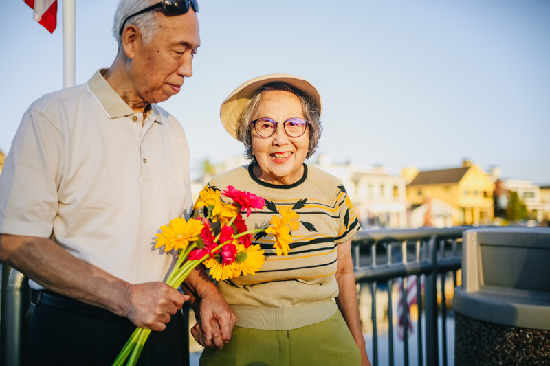 笑顔の妙齢の女性に花束を渡す男性